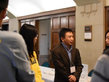 Professor Ji Zhu talking with graduates after the 2017 graduation reception 